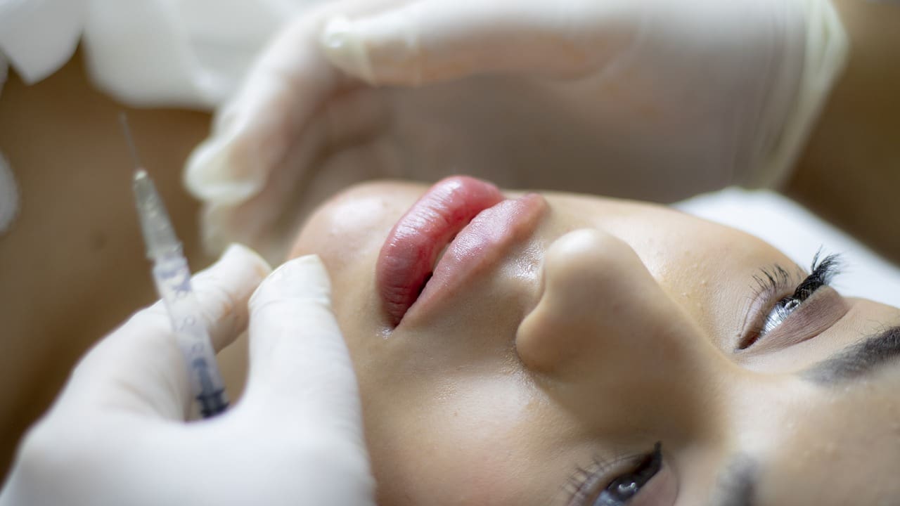 A woman getting her face waxed at the spa