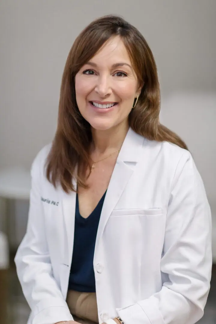 A woman in white lab coat smiling for the camera.